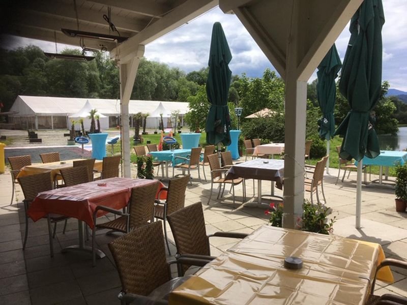 Eine Terrasse mit Tischen und Stühlen.